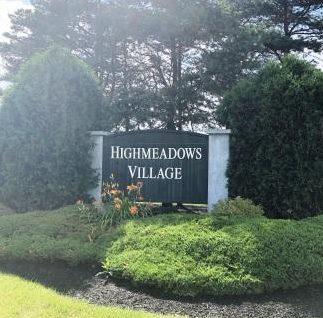 Highmeadows Village neighborhood entrance sign surrounded by lush landscaping